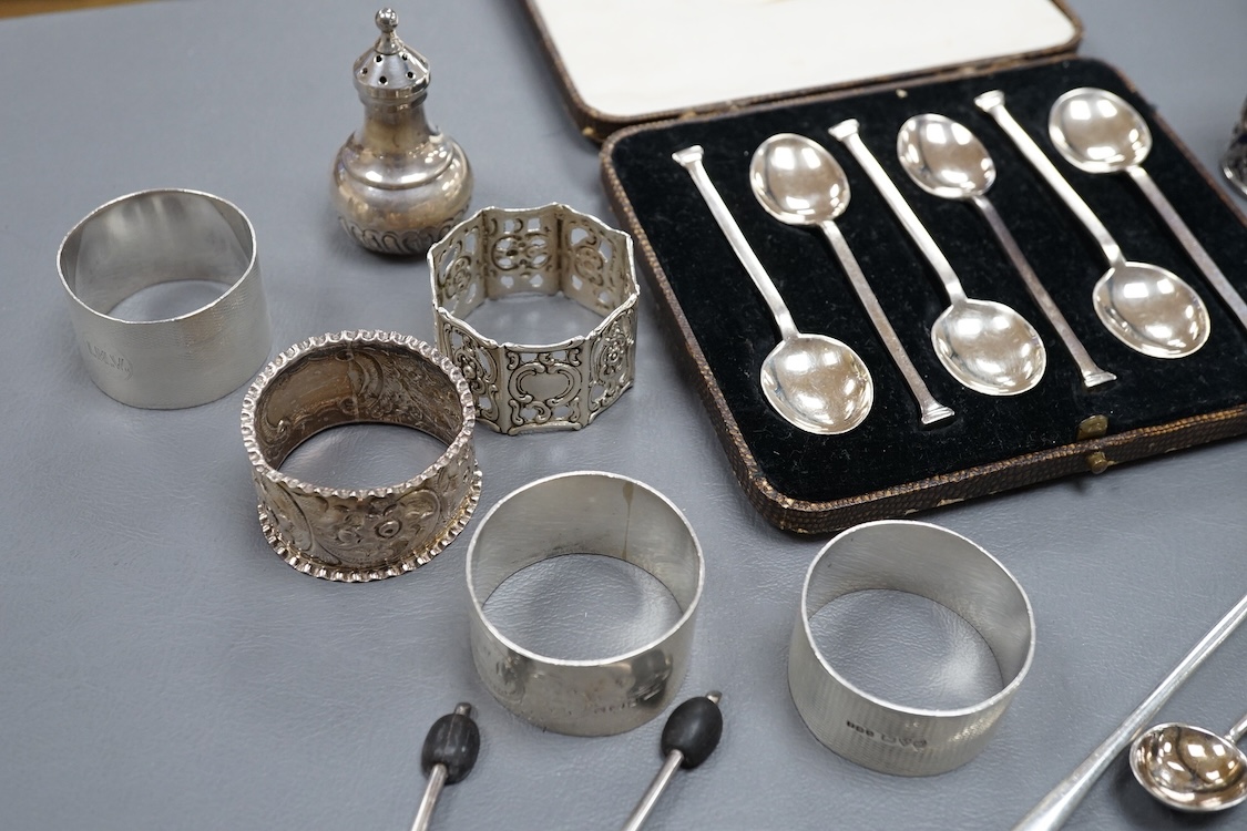 Four assorted silver napkin rings, two cased sets of six silver spoons, four silver condiments including a pair, a small group of sundry flatware, a silver wine label and a plated napkin ring.